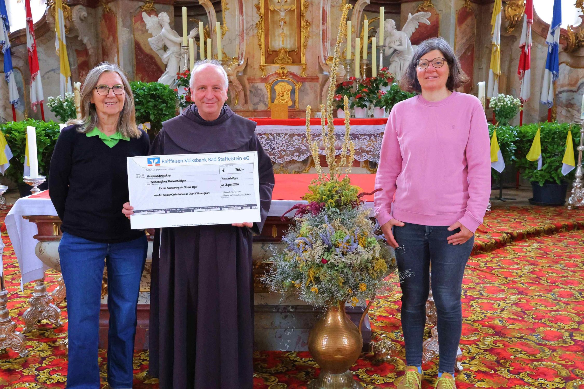 Ursula Bornschlegel (li) von den Blumen- und Gartenfreunden Wolfsdorf sowie Marion Trunk von den Grundfelder Gartenfreunden mit Guardian Pater Maximilian in der Basilika, um den Erlös offiziell zu übergeben. Die Spende kommt der dringend notwendigen Renovierung der Orgel zugute.