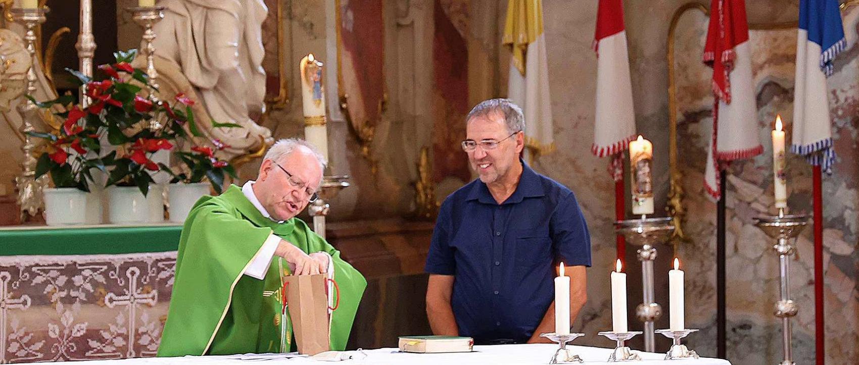 Domkapitular Martin Emge (li) überreichte Pastoralreferent Christian Lauger ein Präsent. Zuvor verabschiedete er den Behindertenseelsorger, der nun eine neue Aufgabe übernehmen wird.