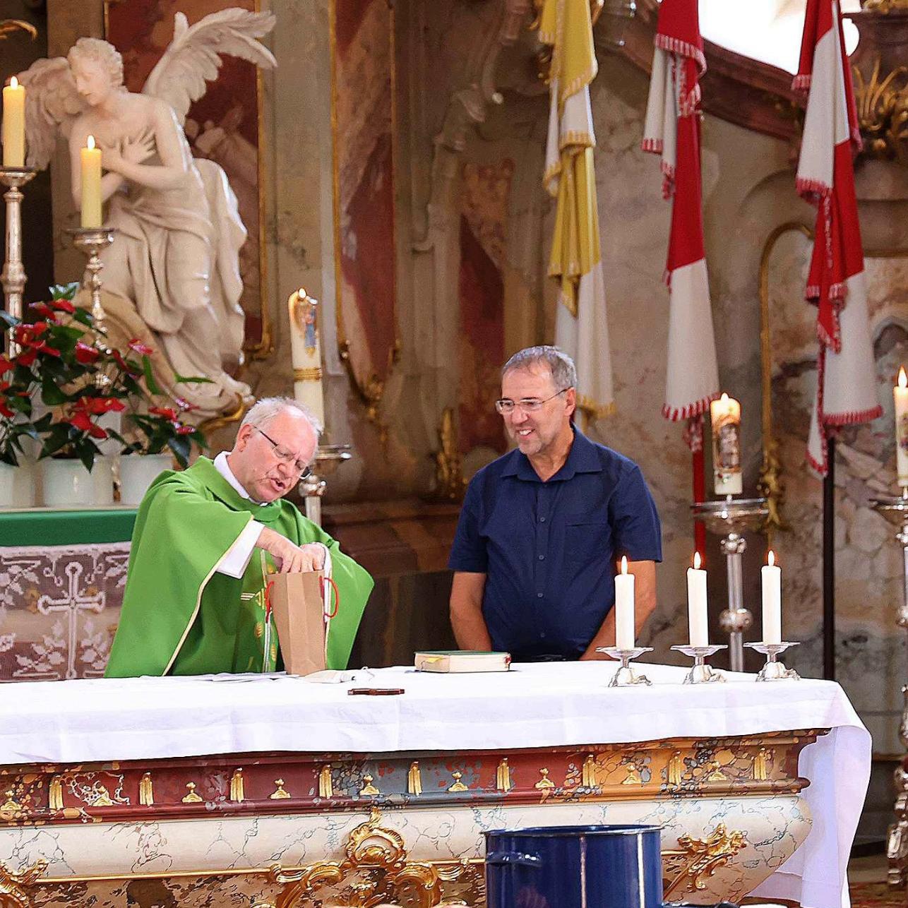 Domkapitular Martin Emge (li) überreichte Pastoralreferent Christian Lauger ein Präsent. Zuvor verabschiedete er den Behindertenseelsorger, der nun eine neue Aufgabe übernehmen wird.