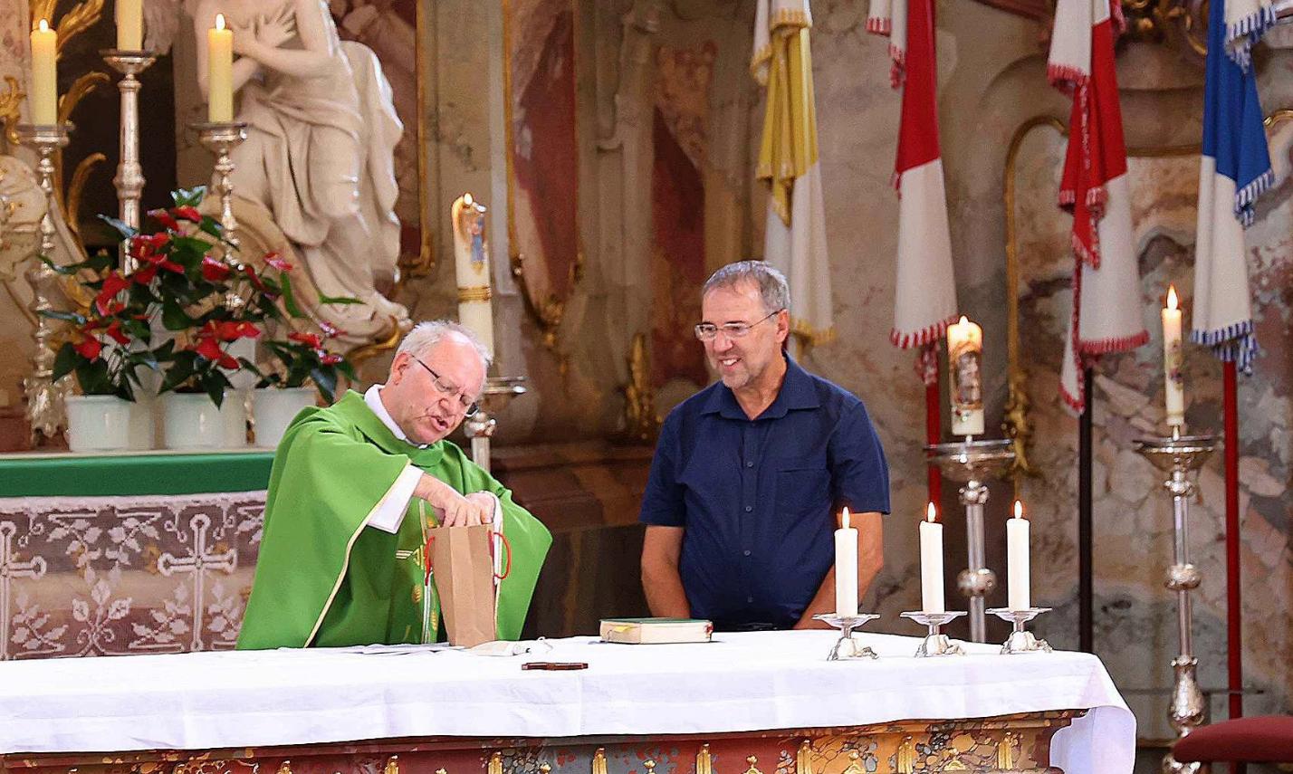 Domkapitular Martin Emge (li) überreichte Pastoralreferent Christian Lauger ein Präsent. Zuvor verabschiedete er den Behindertenseelsorger, der nun eine neue Aufgabe übernehmen wird.