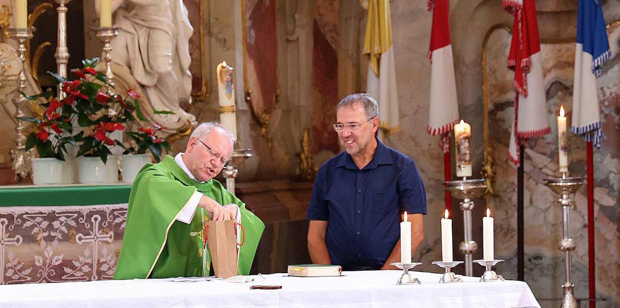 Domkapitular Martin Emge (li) überreichte Pastoralreferent Christian Lauger ein Präsent. Zuvor verabschiedete er den Behindertenseelsorger, der nun eine neue Aufgabe übernehmen wird.